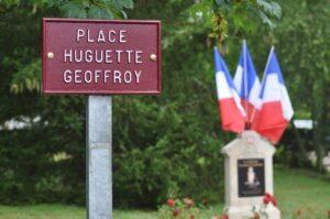 Plaque « Place Huguette Geoffroy » et stèle encadrée de drapeaux tricolores